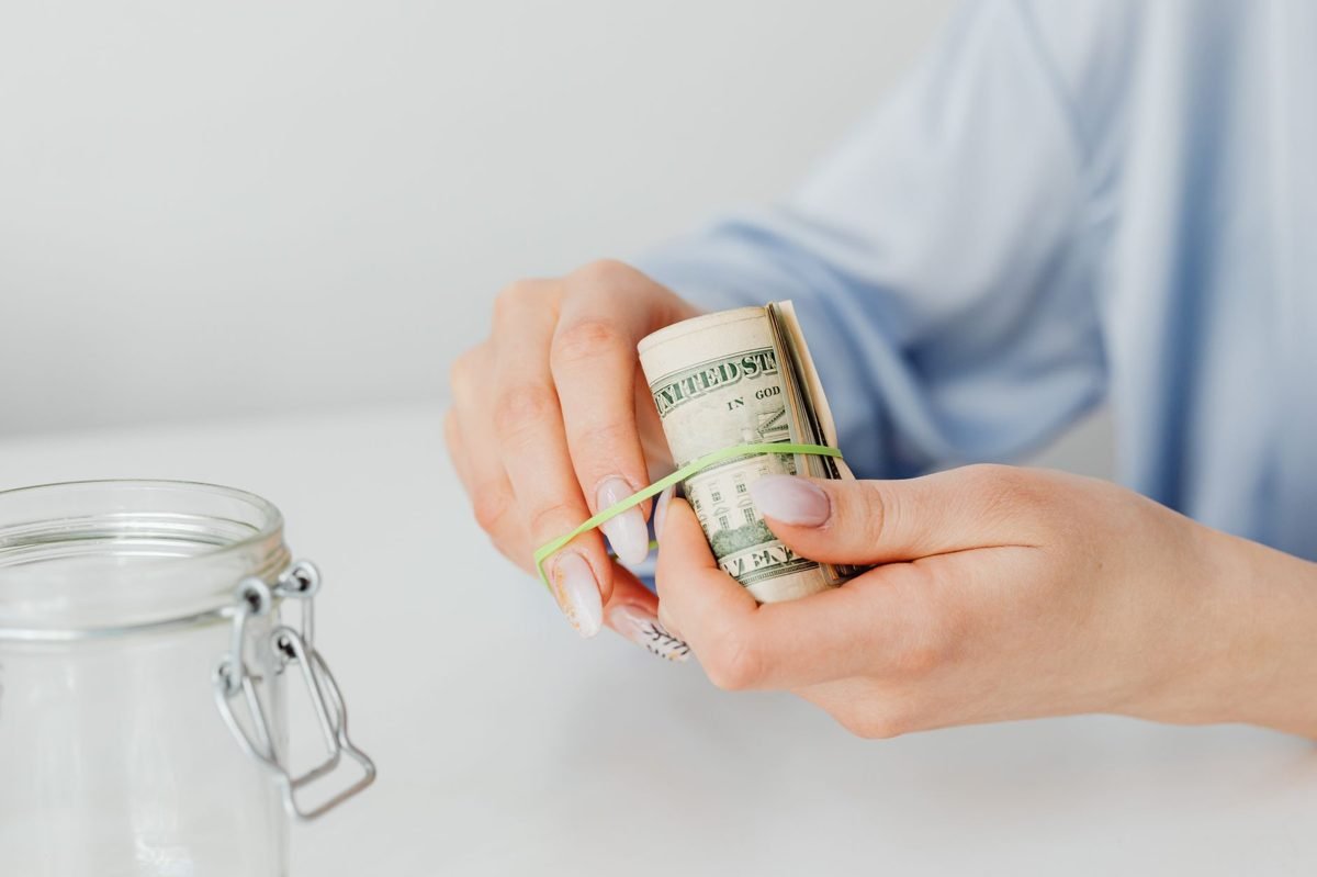 Person reviewing grocery receipts and bills at a kitchen table on a tight budget